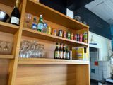 a shelf with bottles and glasses on it in the kitchen