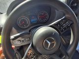 steering wheel and dashboard of a car with a person holding a cell phone