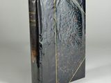a black book with gold trim and a black cover