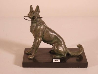 statue of a dog sitting on a base with a leash in its mouth