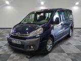 the small blue van is parked on a checkered tile floor