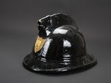 a black fireman ' s helmet with a tag on it
