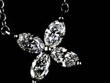 a necklace with a flower made of diamonds on a black background