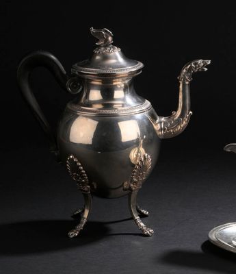 une théière en argent et une assiette en argent posées sur une table