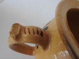 a close up of a brown vase with a handle on it