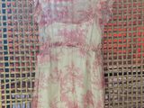 a pink and white dress on a hanger in front of a wall