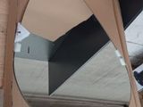 a teddy bear sitting in front of a mirror in a cardboard box