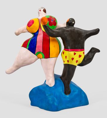 une figurine représentant un homme et un chien jouant avec une balle