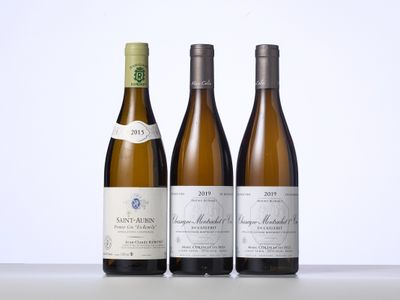 trois bouteilles de vin sont alignées sur une table