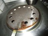 a dirty stove top with a pot on it