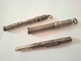 trois stylos à plume différents posés sur une table blanche
