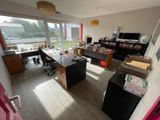 une salle avec de nombreux bureaux et une grande fenêtre