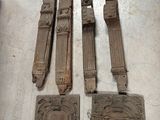 Plusieurs pièces de bois sculpté sont posées sur une table, à côté d'un couteau.