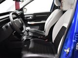 the interior of a small car with black and white seats and a steering wheel
