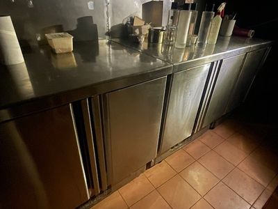 stainless steel counter top in a restaurant kitchen with a lot of bottles on it