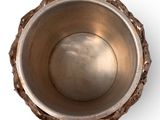 a metal bowl with a metal rim on a white surface