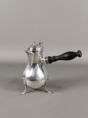 une cafetière en argent avec une poignée noire sur un fond gris