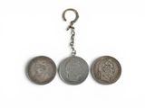 un gros plan sur un porte-clés orné de trois pièces de monnaie