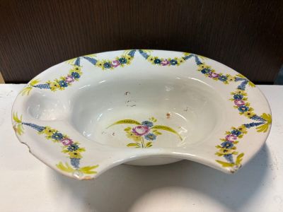 un bol blanc orné de fleurs, posé sur une table
