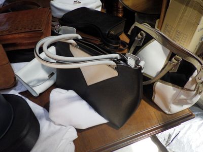 a table with a lot of purses and hats on it