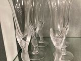 quatre verres à vin posés sur une étagère en verre dans une vitrine en verre