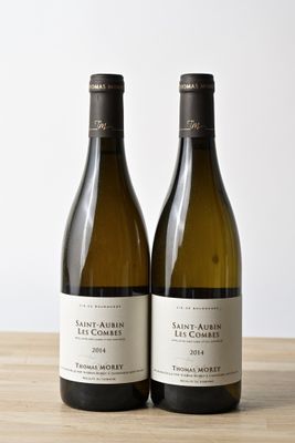 two bottles of wine sitting on top of a wooden table next to each other