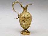 an ornate gold vase with a handle on a white background