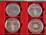 six silver coins in a red box on a red surface