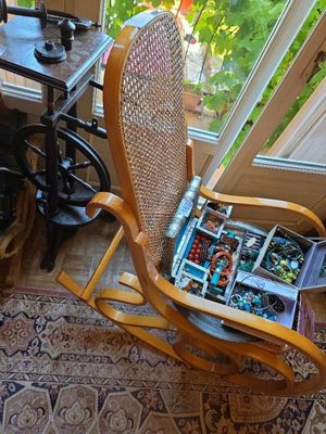 a rocking chair that has a bunch of jewelry in it