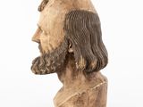 a close up of a wooden bust of a man with long hair