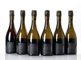six bottles of wine lined up in a row on a white surface