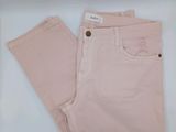 Le pantalon est rose et comporte des boutons.