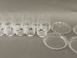 six verres transparents et un lot de six verres vides posés sur une table
