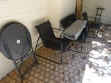 several chairs and a table are lined up against a white brick wall