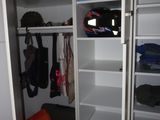 an image of a walk in closet with a lot of clothes