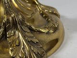 an antique brass plate with a bird on it on a stand