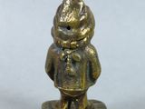 a small bronze figurine of a boy with a hat and tie