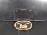 an image of a black purse with a gold buckle on it