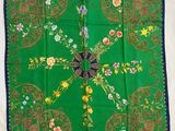 une image représentant une écharpe verte bordée de bleu et ornée de fleurs
