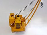 a yellow crane that is sitting on a white surface