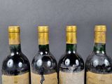 four bottles of wine are lined up on a table