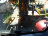 a construction vehicle that is parked next to a gas tank