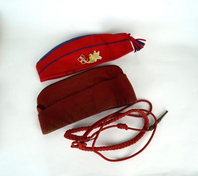 un chapeau rouge et un sac à main rouge posés sur une surface blanche