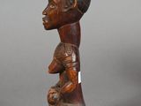 a wooden statue of a woman holding a baby