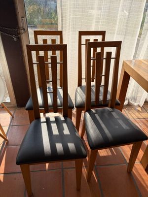 four chairs sitting in front of a window on a tiled floor