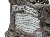 a statue of a skull and a clock on a table