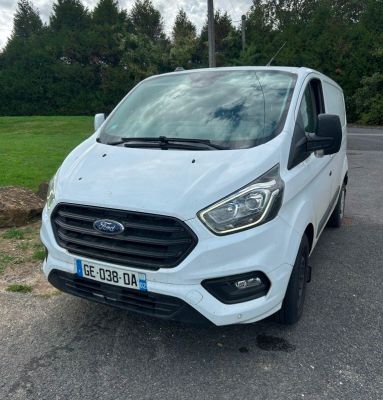 une fourgonnette Ford Transit blanche garée sur un parking
