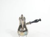 a silver tea pot with a black handle on a white background