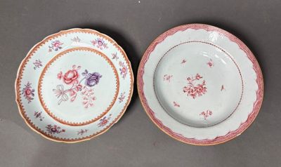 two plates with floral designs on them are sitting on a table