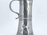 an antique silver plated tankard with a bird on the handle